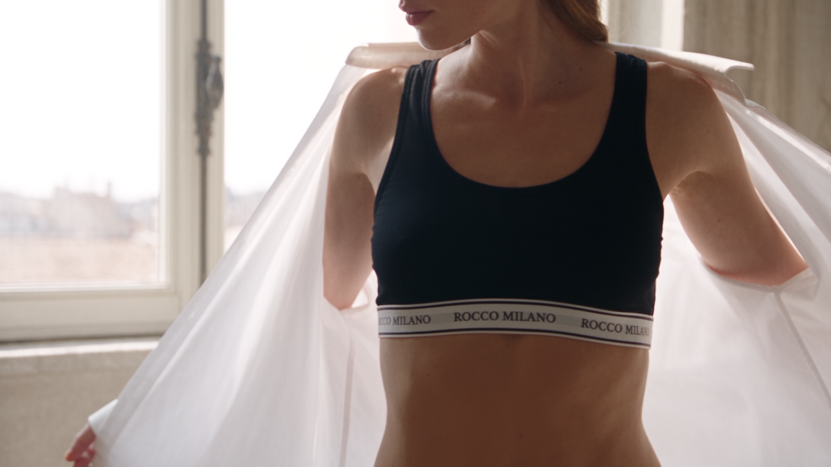 Schwarzes Top mit hellem ROCCO MILANO Logoband am Model